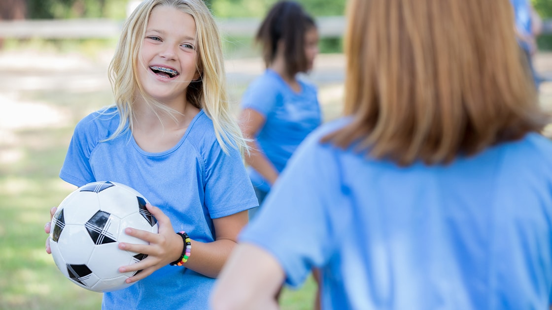 Girl Playing Soccer During Braces Treatment